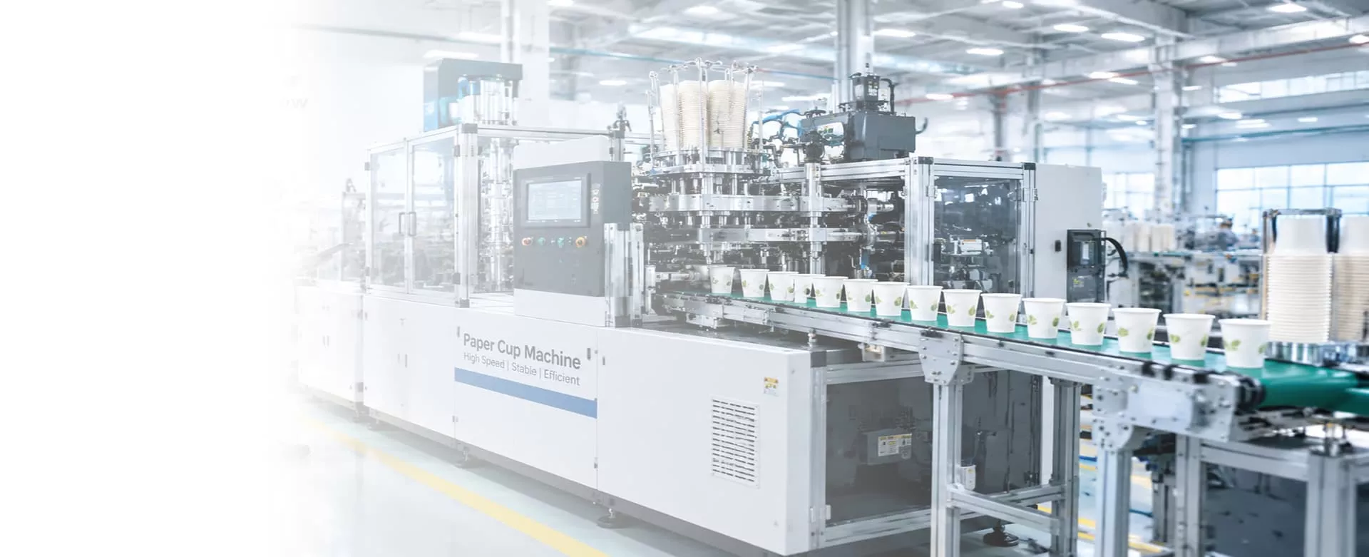 Paper Cup Machine in a factory producing finished paper cups on a conveyor belt